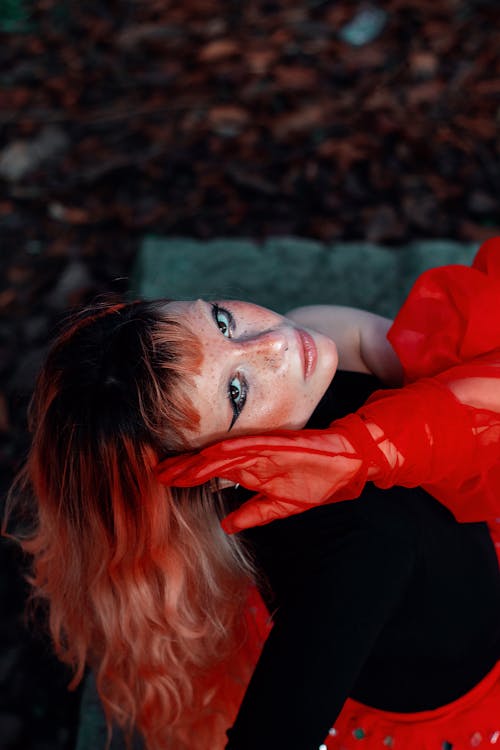 A woman with red hair and red gloves