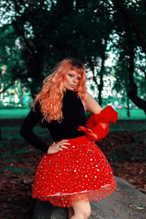 A woman with red hair and a red skirt