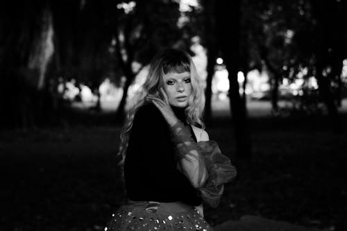 Black and White Photo of a Young Woman Posing in a Park