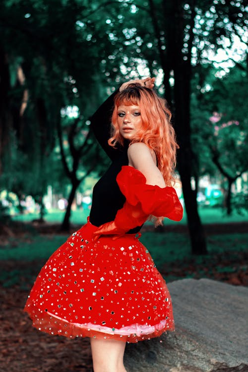 A woman in red and black tutu skirt posing