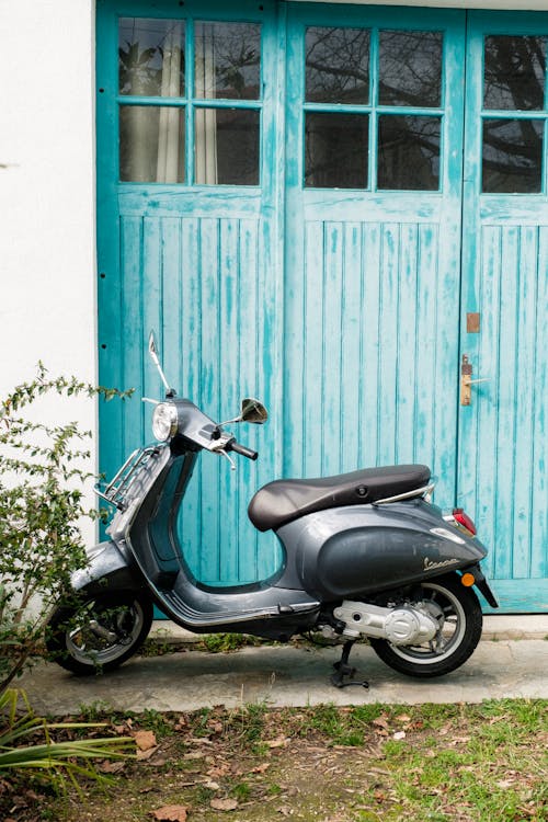 A moped parked in front of a blue door