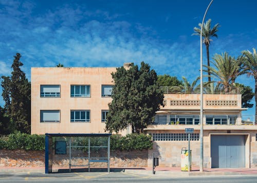 A building with a blue roof and palm trees