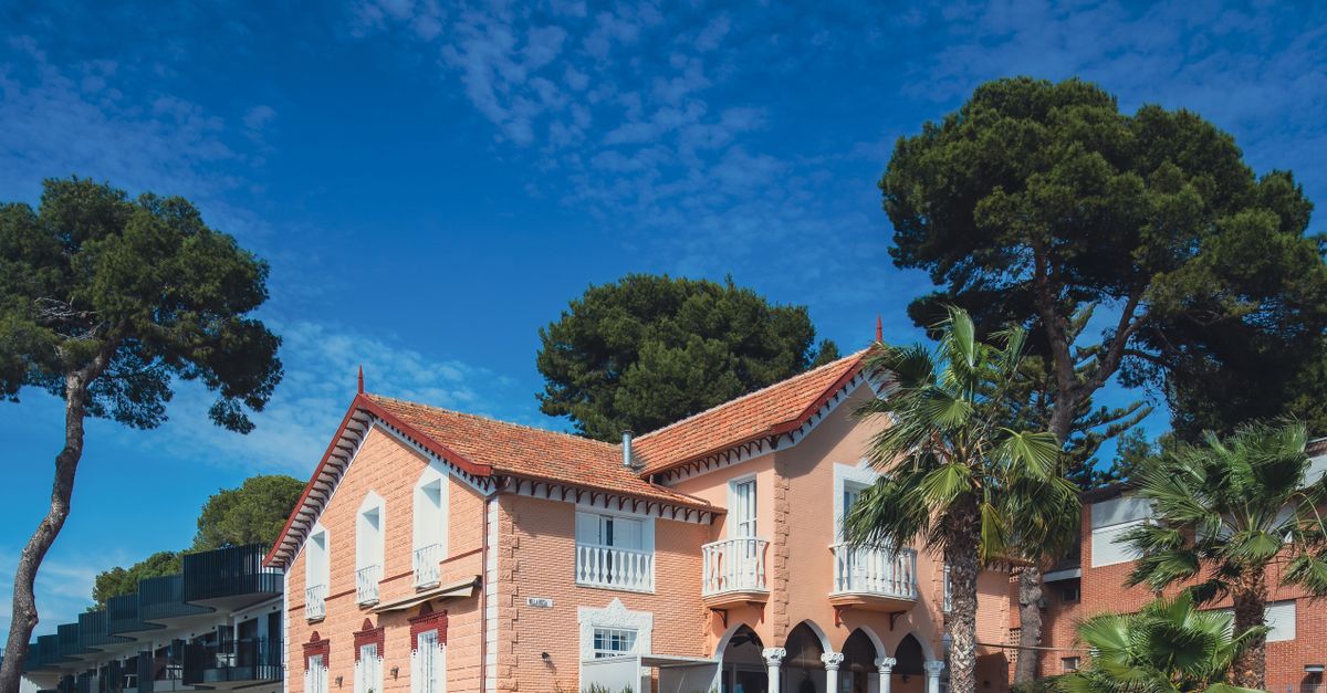 Picturesque villa in San Javier, Spain surrounded by lush trees and vibrant blue sky, ideal for travel enthusiasts.