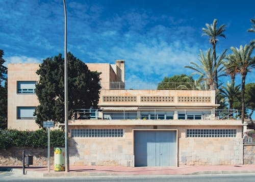 A building with palm trees and a blue sky