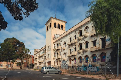 A building with graffiti on it and a car parked in front of it