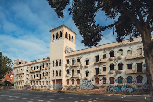 An old building with graffiti on it and trees