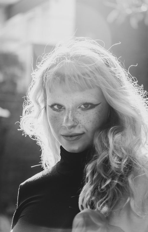 Free Stunning black and white portrait of a young woman with freckles and chic makeup, exuding elegance and style. Stock Photo