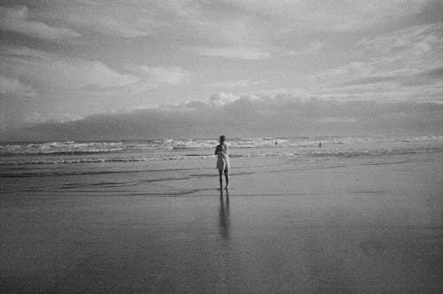 Woman Standing on Beach in Black and White
