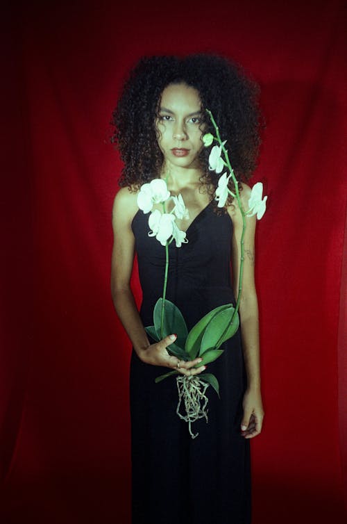 A woman in a black dress holding flowers