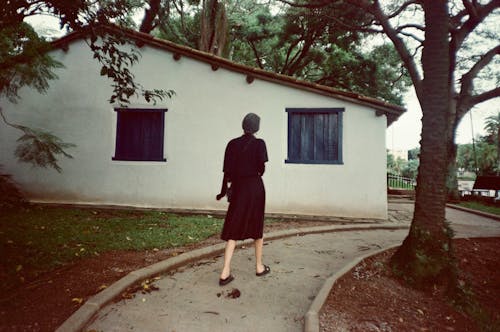 A woman walking down a path in front of a house