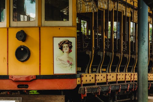 A yellow train with a woman on the side