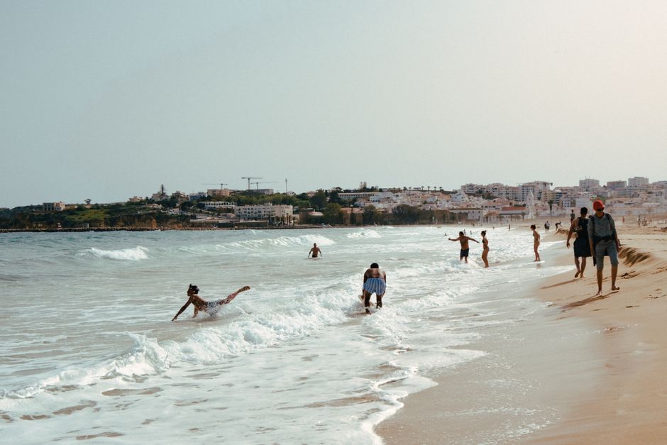 People enjoying the waves and sun on a beautiful beach in Lagos, Portugal.