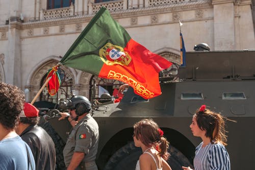 A group of people standing in front of an armored vehicle
