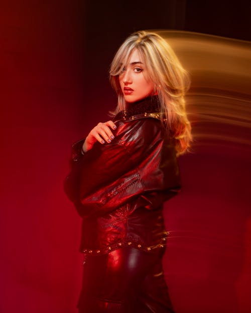 A woman in leather jacket and red lighting