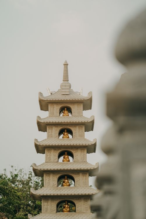 Free A serene Buddhist pagoda featuring intricate design and golden Buddha statues in Vietnam. Stock Photo