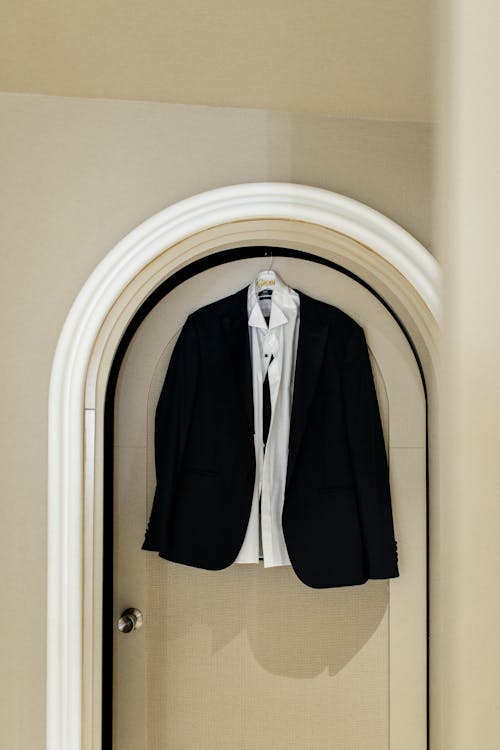 A black suit hanging on a door