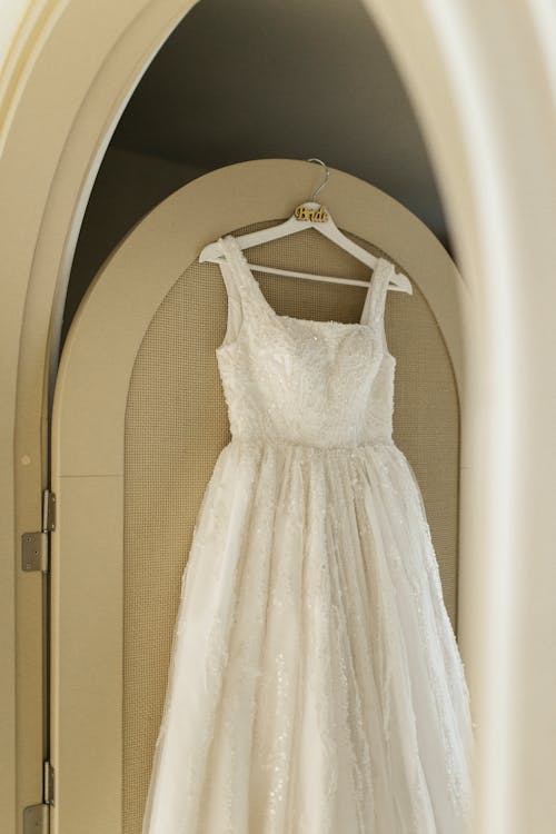 A wedding dress hanging in a mirror
