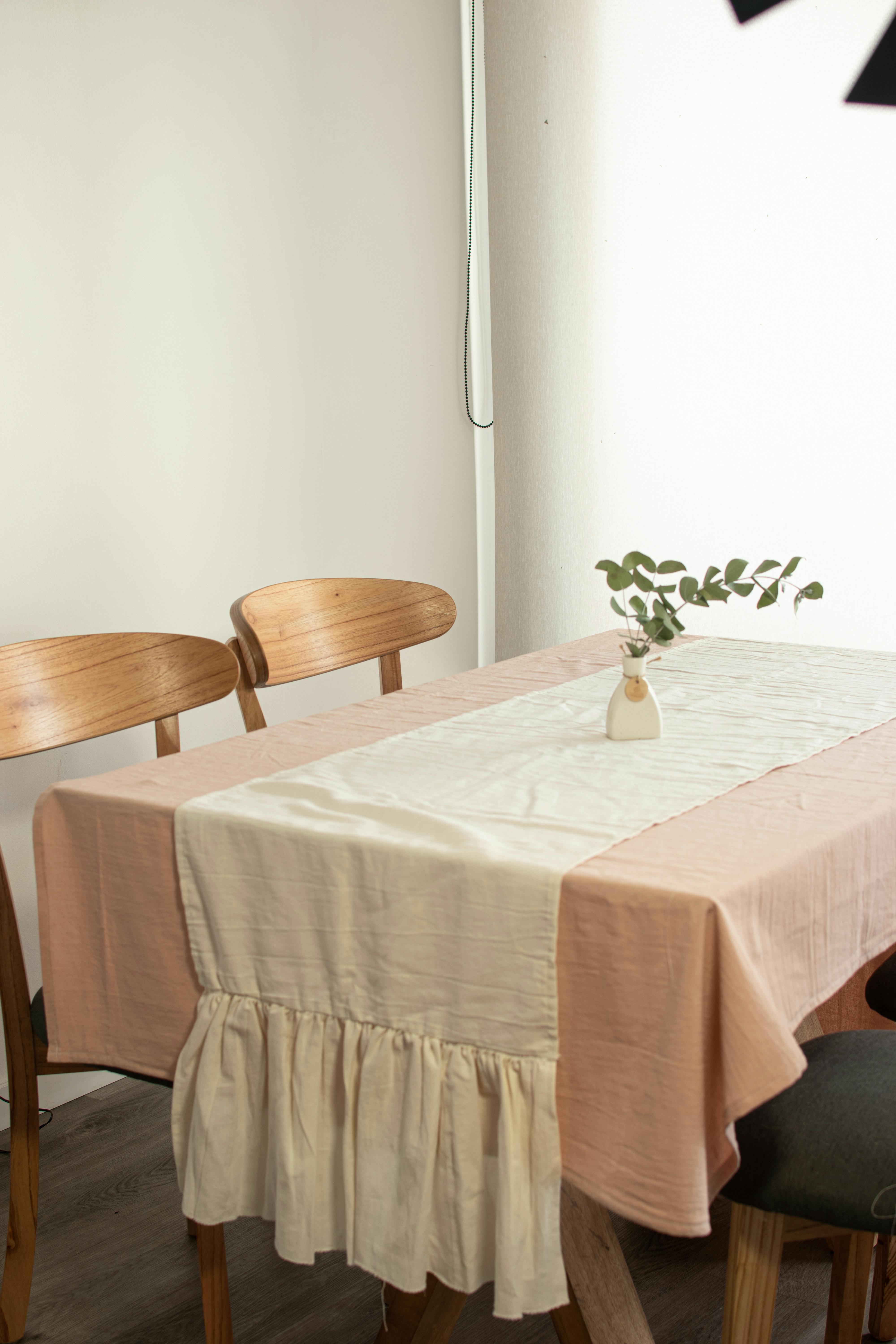 A simple and elegant dining room setup featuring a wooden table and chairs with minimalist interior design.