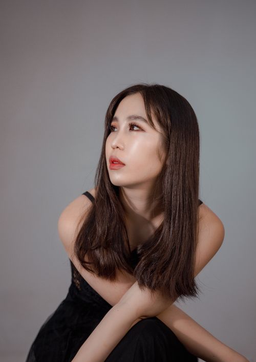 Free Portrait of an Asian woman with long brown hair in a studio setting, showcasing elegance and style. Stock Photo