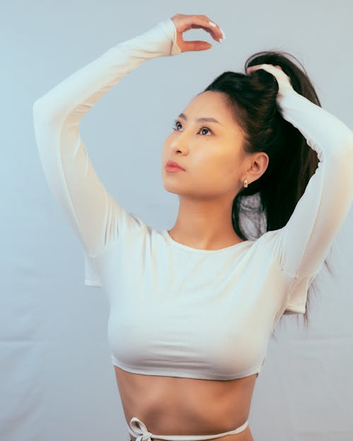 Gratis lagerfoto af asiatisk kvinde, fastsættelse af hår, hvid baggrund