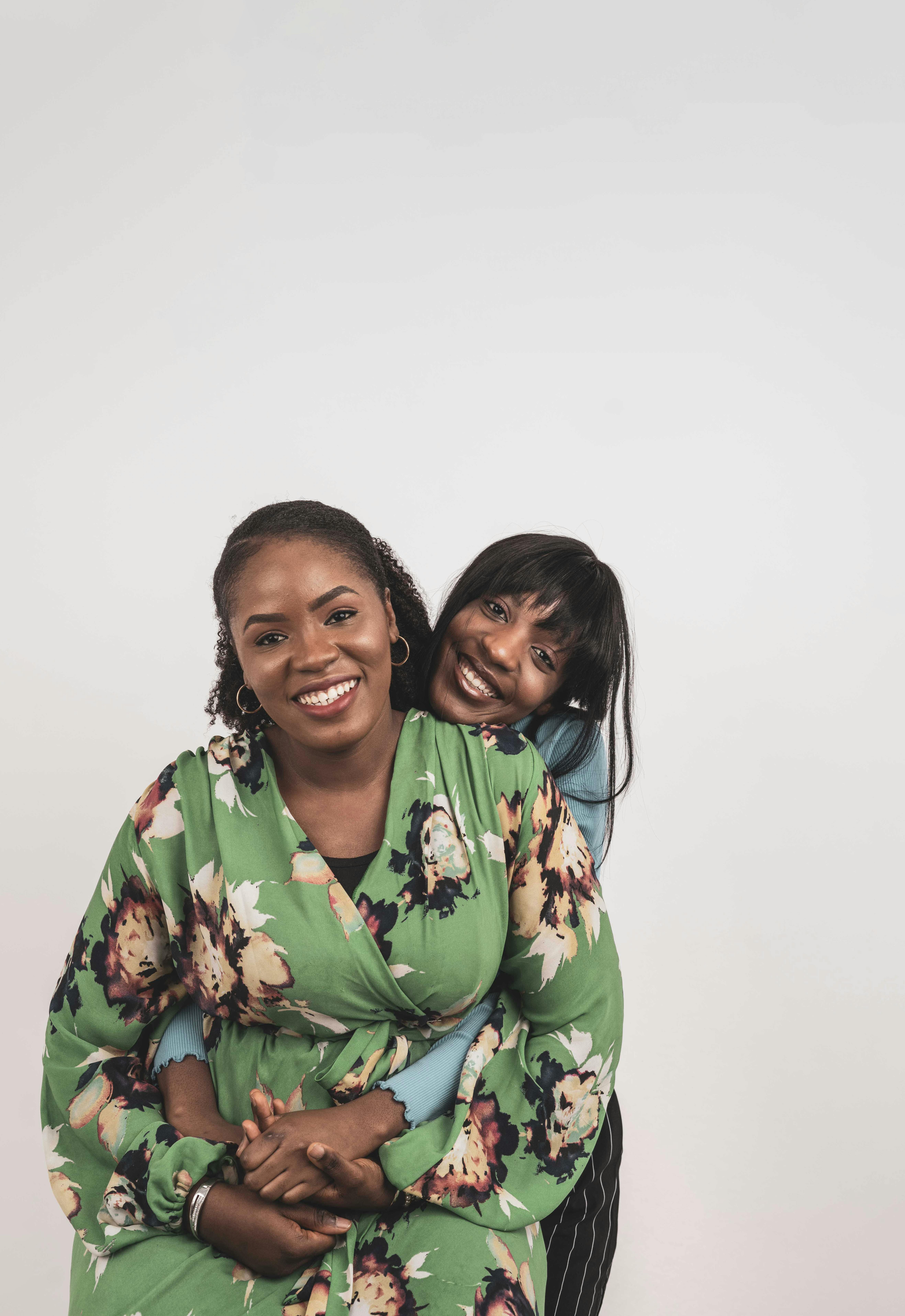 Two women sharing a joyful embrace, showcasing sisterhood with vibrant floral attire.