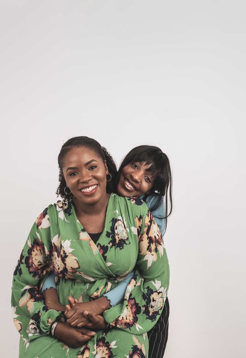 Free Two women sharing a joyful embrace, showcasing sisterhood with vibrant floral attire. Stock Photo
