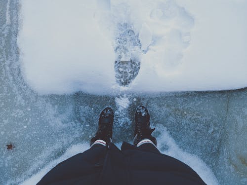 Standing on the Ice in Front of a Large Footprint in the Snow on the Ice