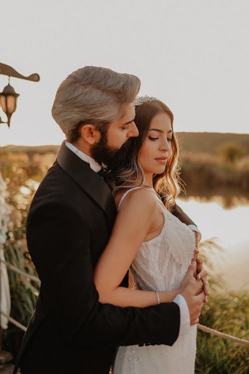  Gray-haired Man in a Tuxedo Embracing a Woman in a White Dress