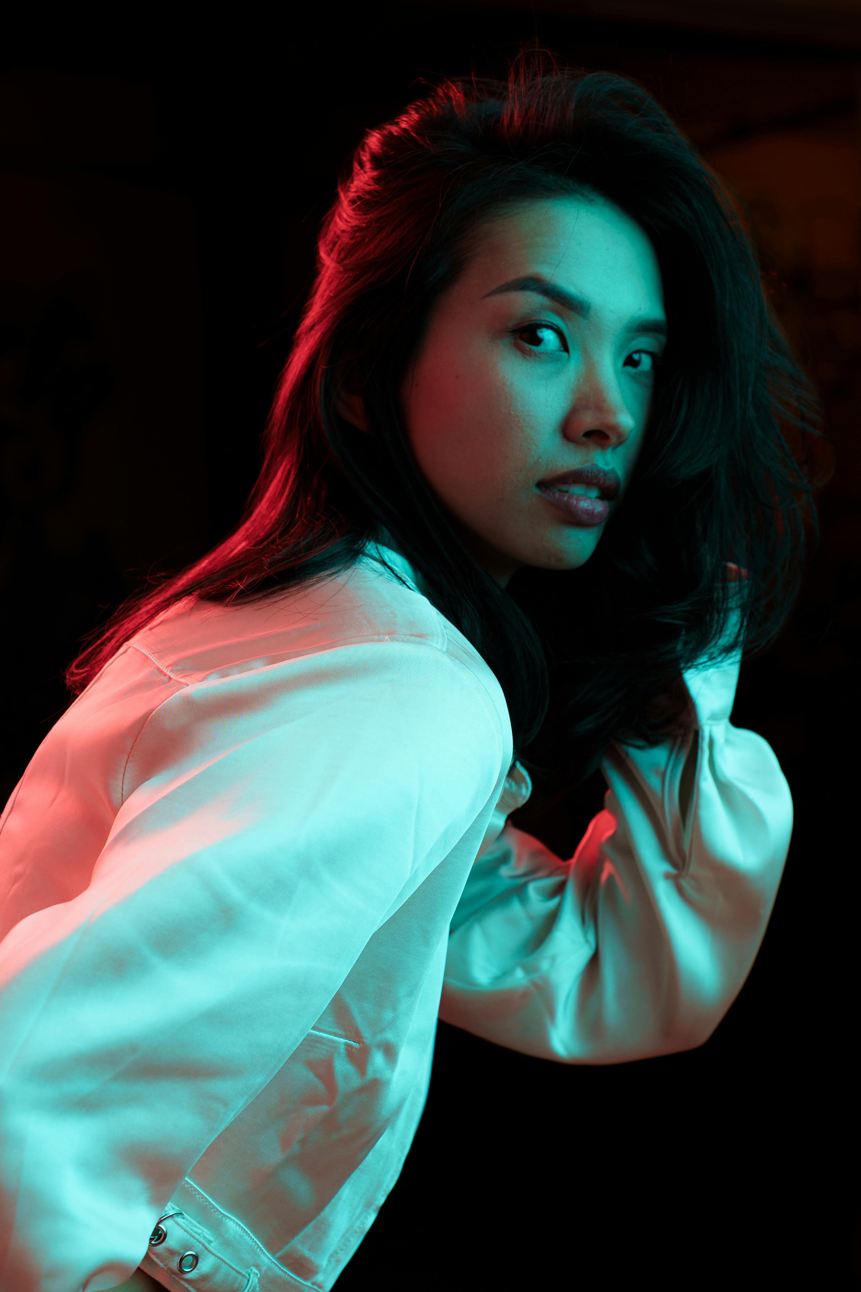 woman with long black hair posing in duotone lighting · Free Stock Photo