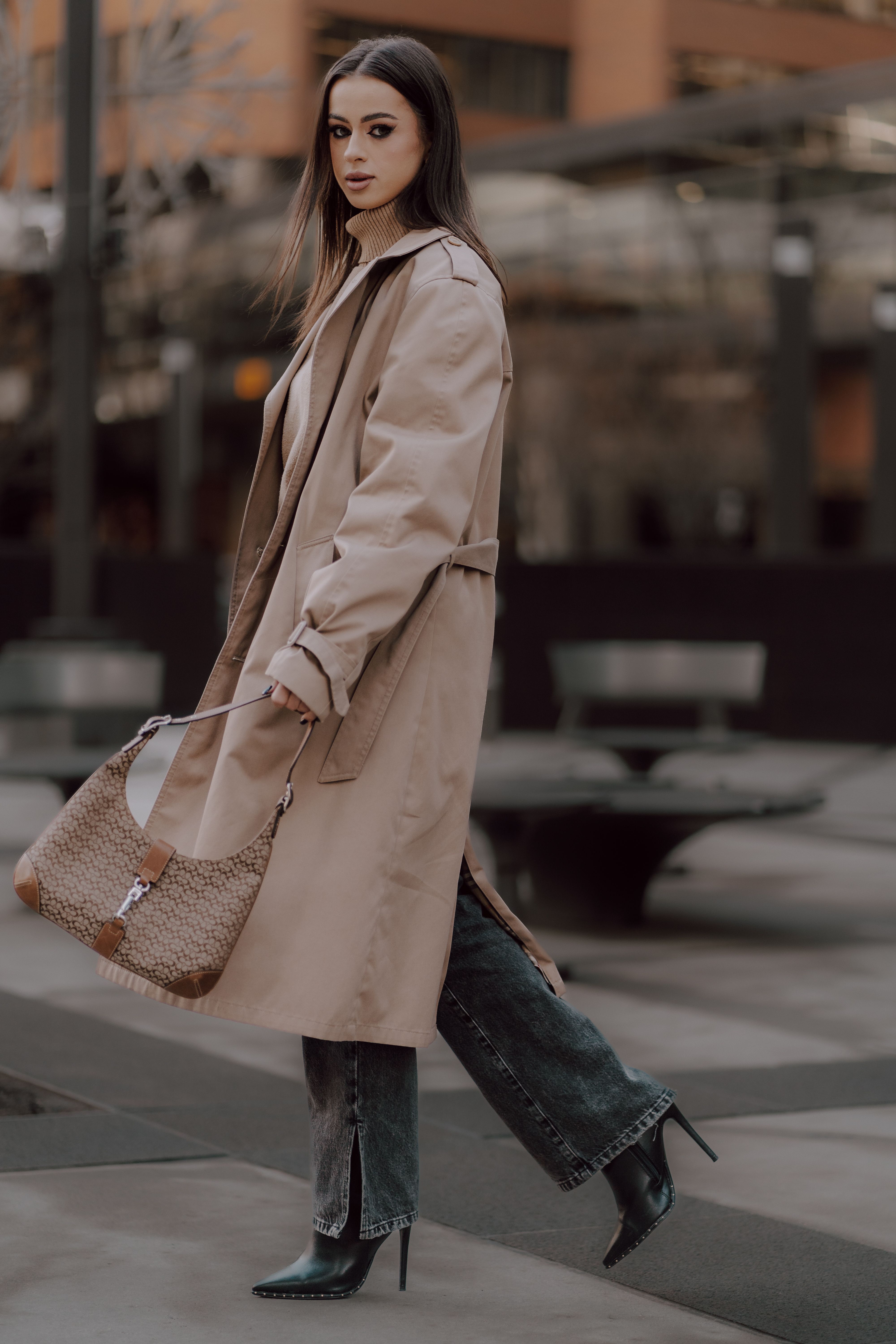 A woman in a trench coat and heels walking down the street · Free Stock ...