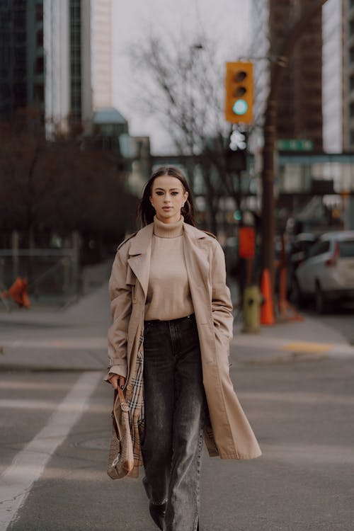 A woman walking down the street in a trench coat