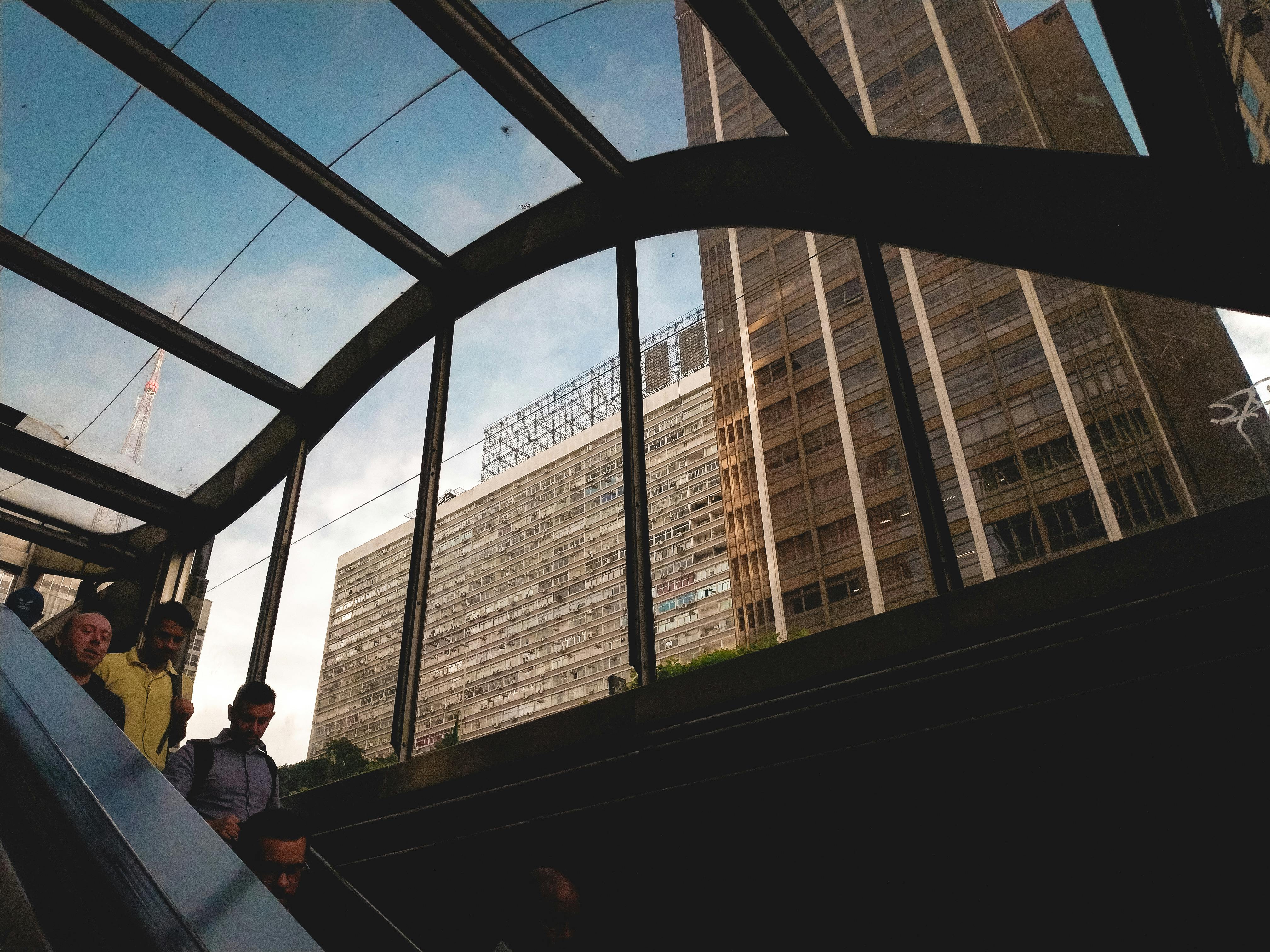 一个动态的城市场景捕捉了人们通过玻璃结构在自动扶梯上观看摩天大楼的景象