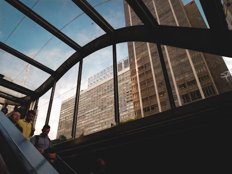 一个动态的城市场景捕捉了人们通过玻璃结构在自动扶梯上观看摩天大楼的景象