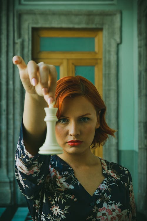 Woman Holding a Chess Piece in Front of Her