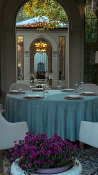 Beautifully set table in an elegant venue with an arched entry, showcasing classic decor and greenery.