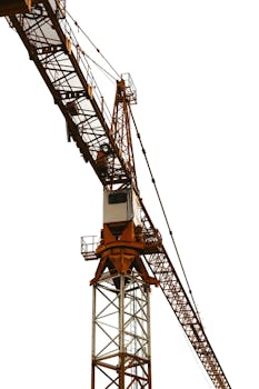 Vertical shot of a tower crane on a construction site with a white background.