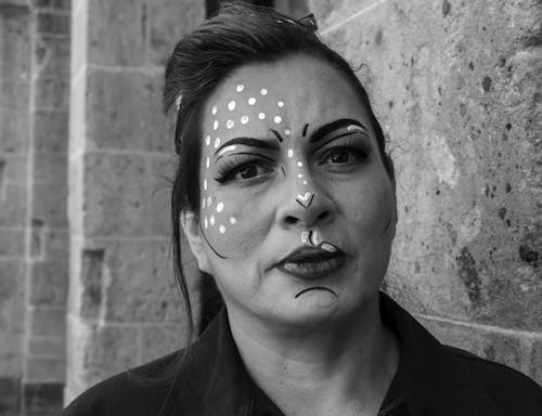 A woman with face paint and a black and white photo