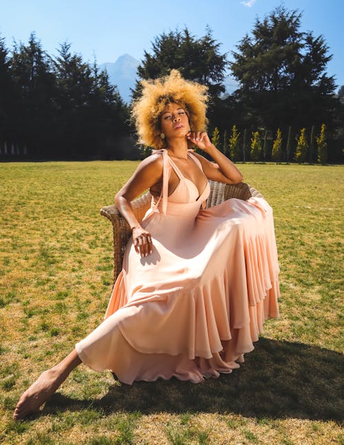 A woman in a pink dress sitting on a chair