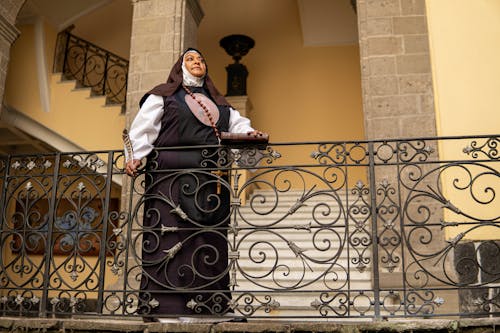 A nun standing on a balcony