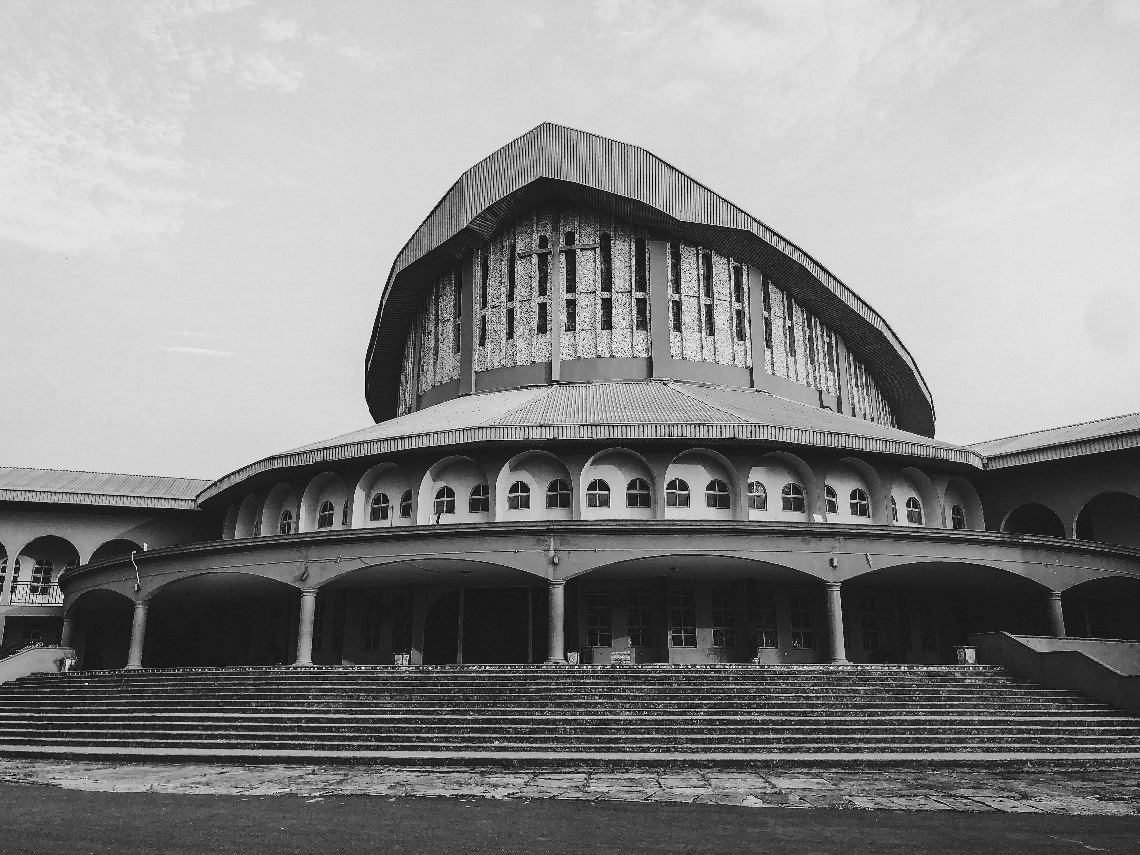 Young people in modern clothing walking into a large modern church building in Ho, Ghana