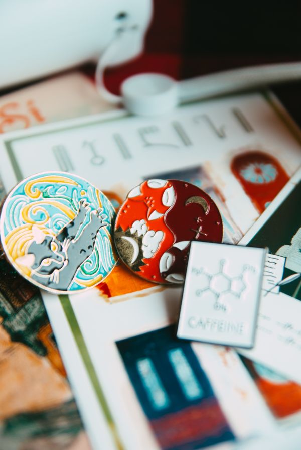 Colourful enamel pins arranged on paper — photo by Dagmara Dombrovska on Pexels