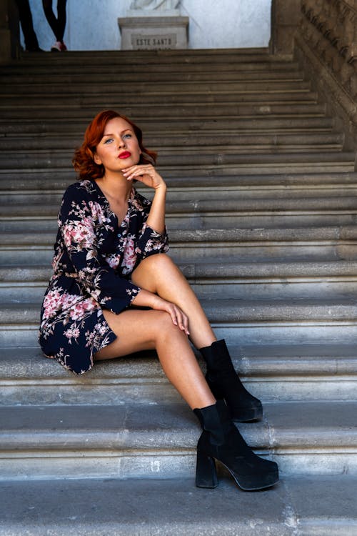 A woman sitting on some stairs with her legs crossed
