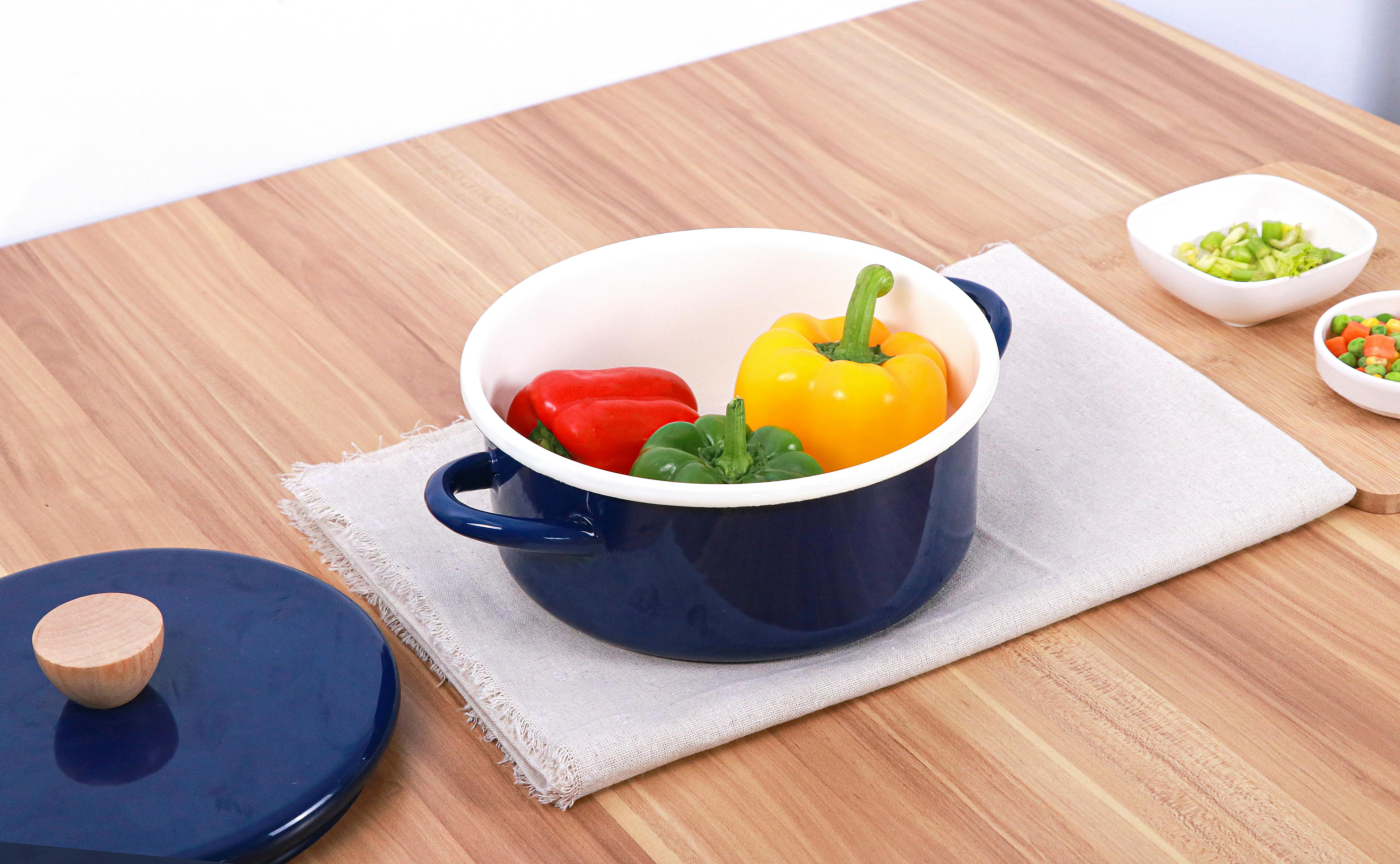 Colorful peppers in a blue pot on a wooden table, ideal for cooking and kitchenware themes.