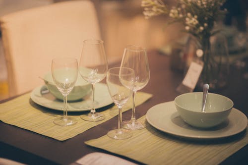 Free A table setting with green placemats and glasses Stock Photo