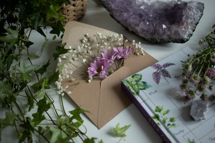 Close-up Of Flowers In An Envelope And Crystals On A Table