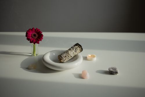 Free Elegant arrangement of aromatherapy essentials with sage, gerbera, and crystals on a white surface. Stock Photo