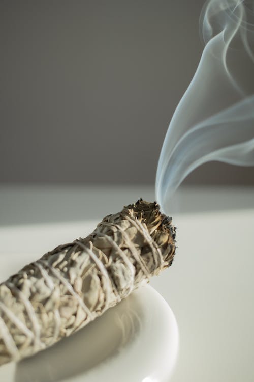 A Burning Incense on a White Plate Standing on a White Table 