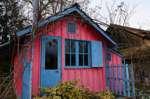 A small pink house with blue shutters