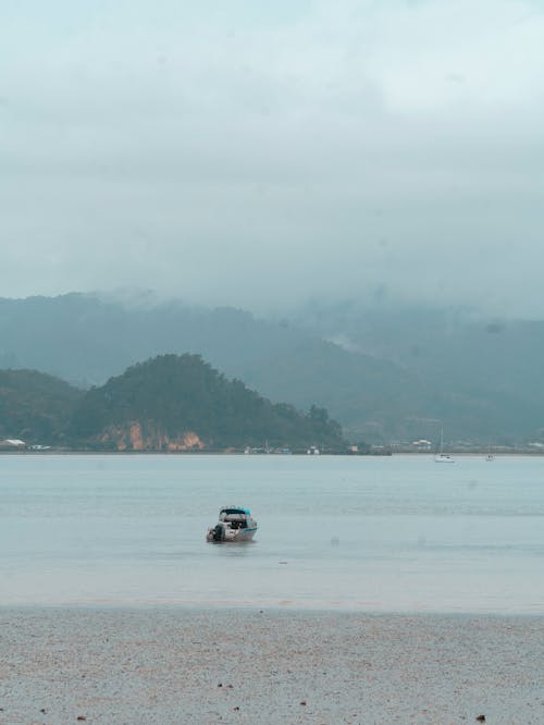 A boat is sitting on the water in front of mountains