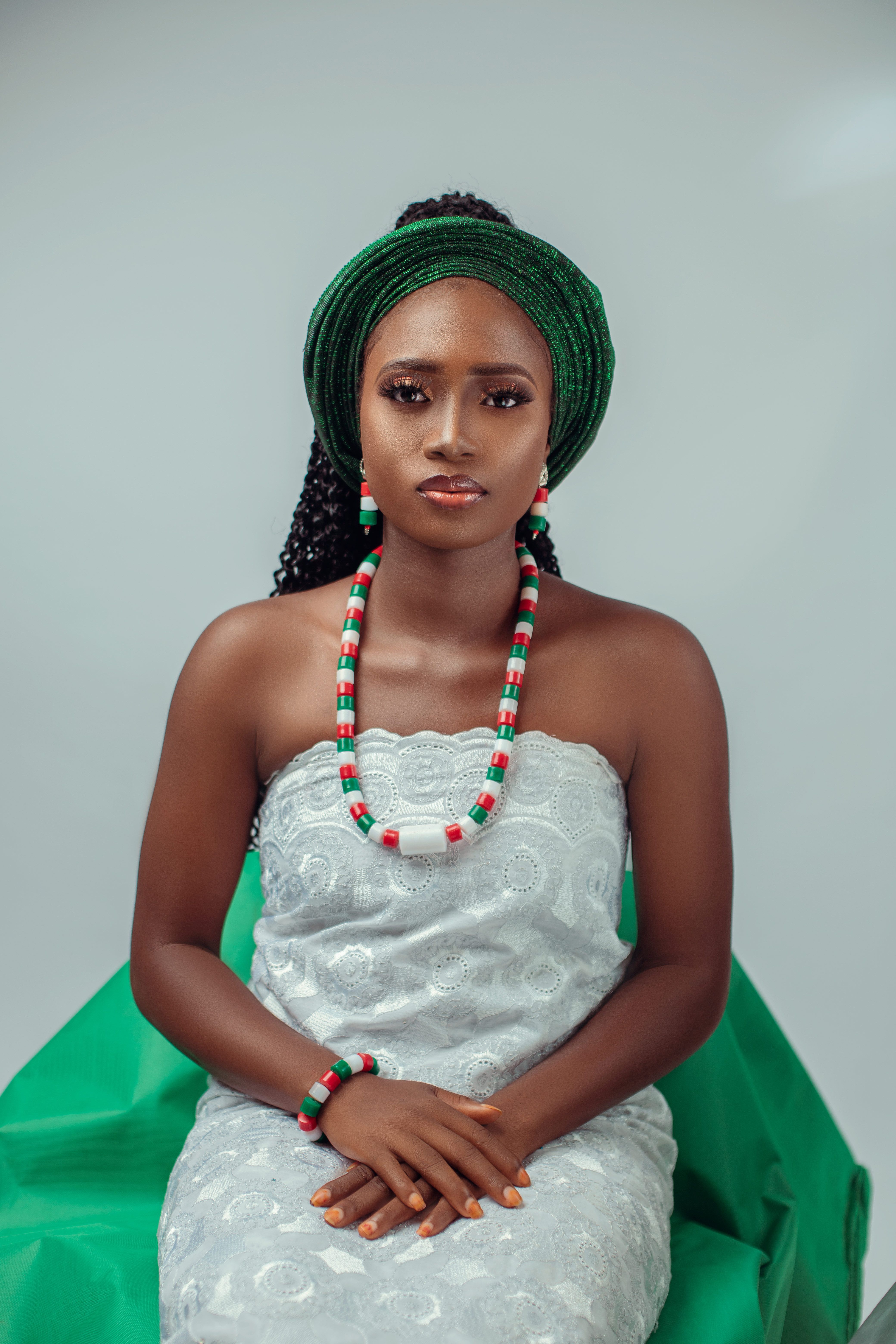 Studio Shot of an Elegant Woman in a White Dress and Green Headdress  Free  Stock Photo